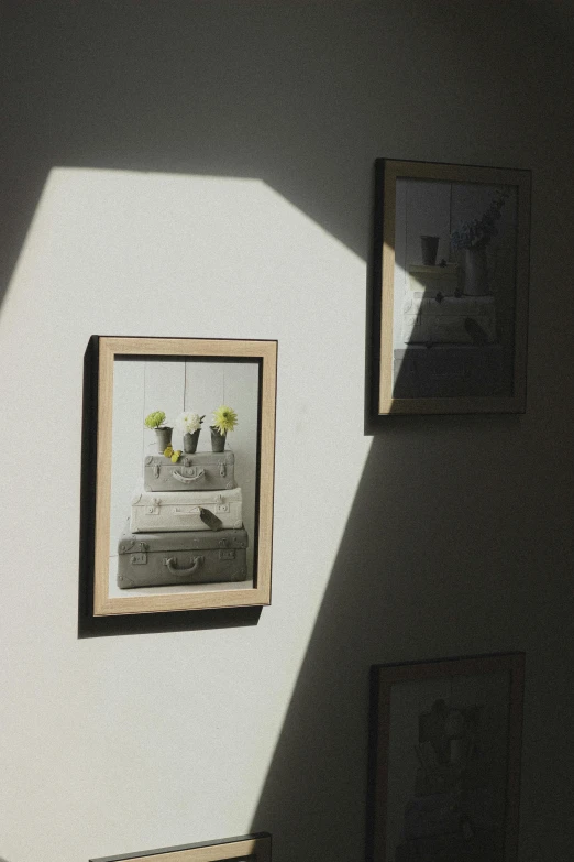a couple of pictures hanging on a wall, inspired by André Kertész, unsplash, soft sun lights, ( ( photograph ) ), backlighted, tightly framed