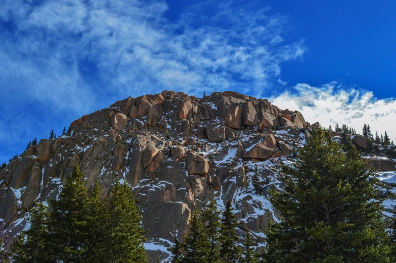 a mountain covered in snow and trees under a blue sky, a photo, by Chris Cold, unsplash, extremely detailed rocky crag, mammoth, today\'s featured photograph 4k, multiple stories