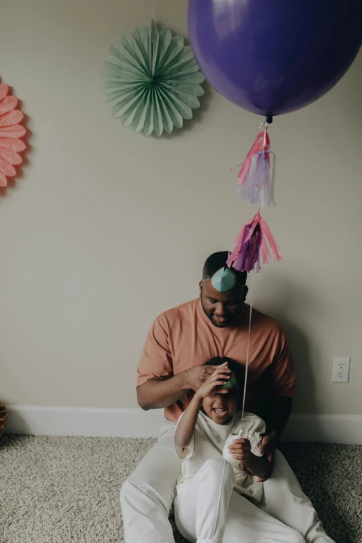 a man sitting on the floor with a dog and a balloon, caring fatherly wide forehead, wearing a pink head band, ray lewis, profile image