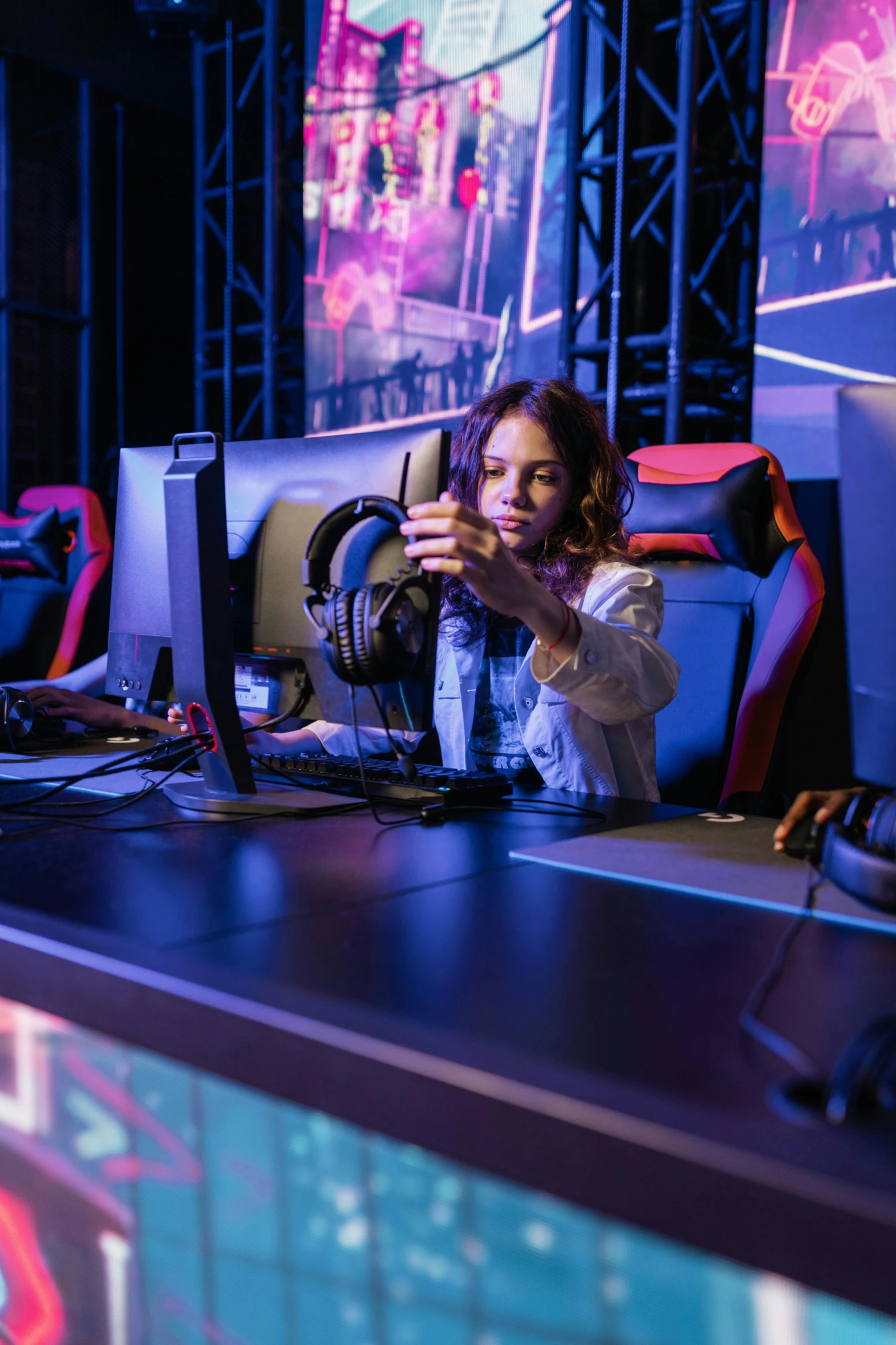 a woman sitting at a desk in front of a computer, by Adam Marczyński, esports, children's, checking her phone, performing on stage