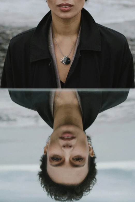 a woman standing in front of a glass table, an album cover, inspired by Anna Füssli, trending on pexels, androgynous face, black jewelry, symmetry!! portrait of a woman, upside down