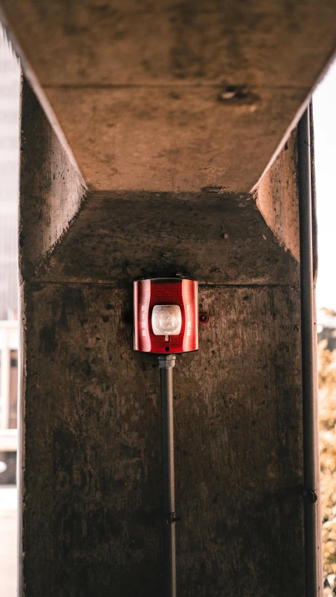 a red light that is on the side of a building, a cartoon, unsplash, modernism, security camera photo, brutalist design, dwell, lantern