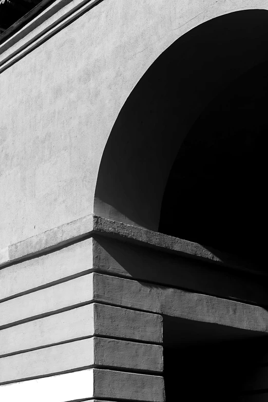 a man riding a skateboard up the side of a building, a black and white photo, inspired by Edward Weston, postminimalism, white stone arches, detail structure, monochrome:-2, made of cement