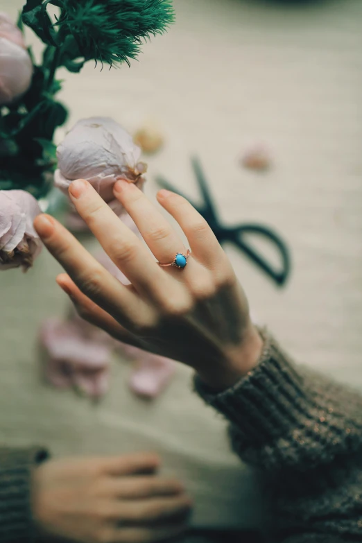 a close up of a person holding a flower, turquoise, ring, ((blue)), romantic lead