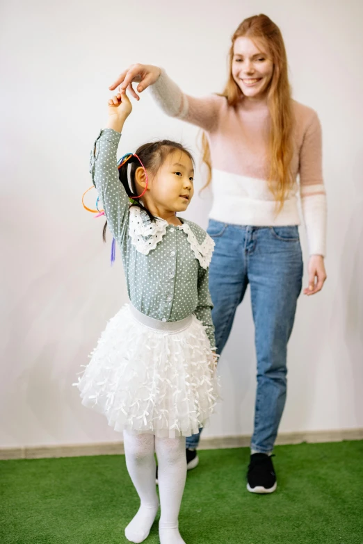 a woman standing next to a little girl in a white dress, dance party, wearing casual clothing, louise zhang, educational