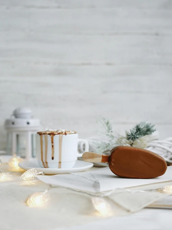 a dessert sitting on top of a table next to a cup of coffee, inspired by Ödön Márffy, winter vibes, giant wooden club, high quality product image”, bronze