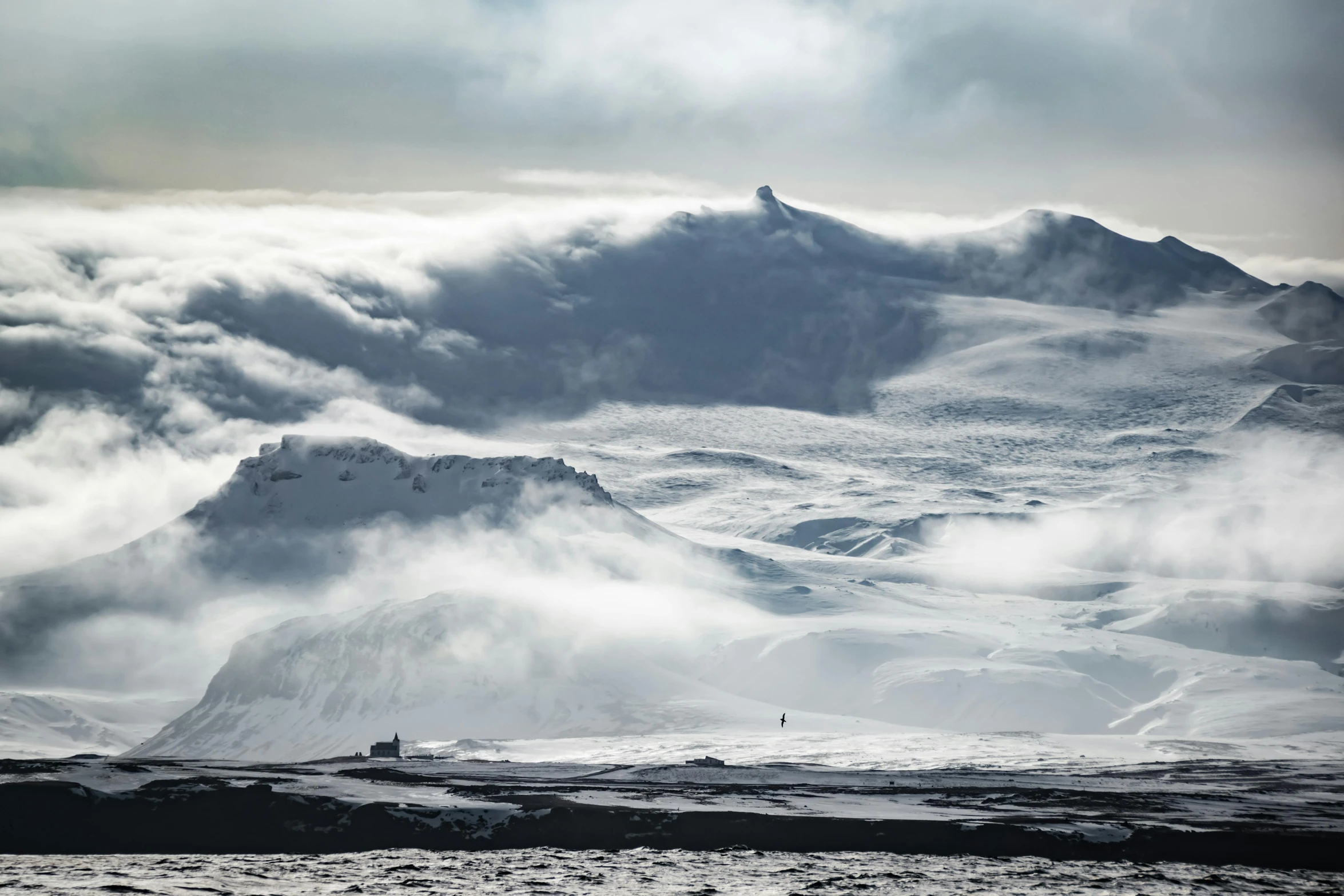 a group of people standing on top of a snow covered mountain, by Daniel Seghers, pexels contest winner, romanticism, clouds and waves, old cowboy in the arctic, viewed from a distance, black volcano afar