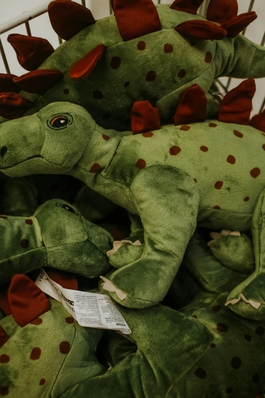 a pile of stuffed dinosaurs sitting on top of each other, by Matija Jama, pexels, ((in a super market costco)), green dragon, spots, teenager