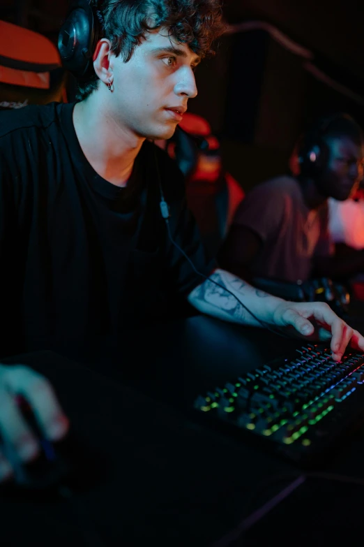 a man sitting at a desk in front of a computer, led gamers keyboard, at a rave, cover shot, background image