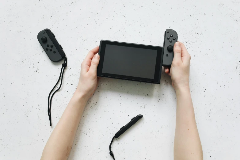 a person holding a nintendo wii game controller, unsplash, minimalism, black canvas, nintendo switch, cinematic outfit photo