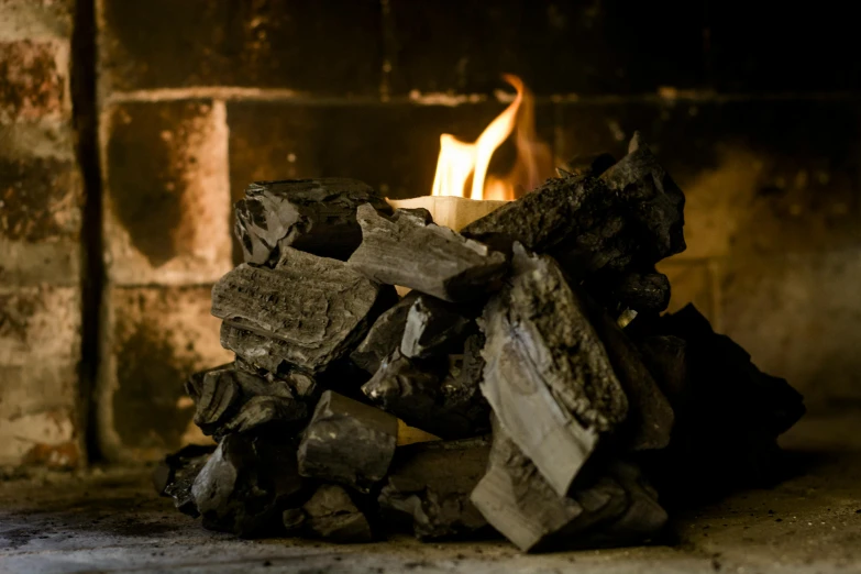 a lit candle sitting on top of a pile of wood, a charcoal drawing, pexels contest winner, smokey chimney, slate, gas fire in cracks, bog oak