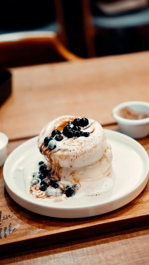 a close up of a plate of food on a table, by Lee Loughridge, unsplash, whipped cream on top, blueberry, caramel. rugged, bao phan