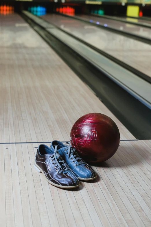 a pair of shoes sitting on the floor next to a bowling ball, bowl, lane brown, up close, slate