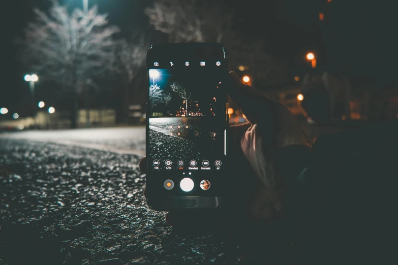 a person taking a picture of a street at night, pexels contest winner, realism, android close to camera, mobile wallpaper, crawling towards the camera, bokeh. chrome accents