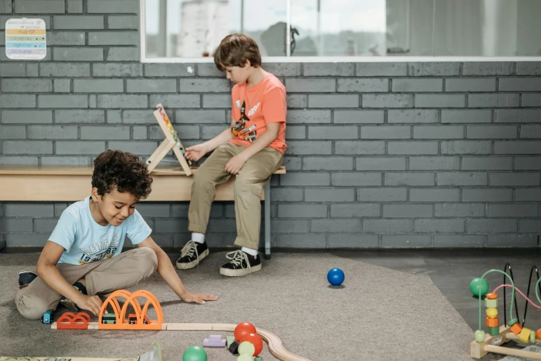 two children sitting on a bench playing with toys, by Nick Fudge, pexels contest winner, newton's cradle, two buddies sitting in a room, lachlan bailey, standing sideways