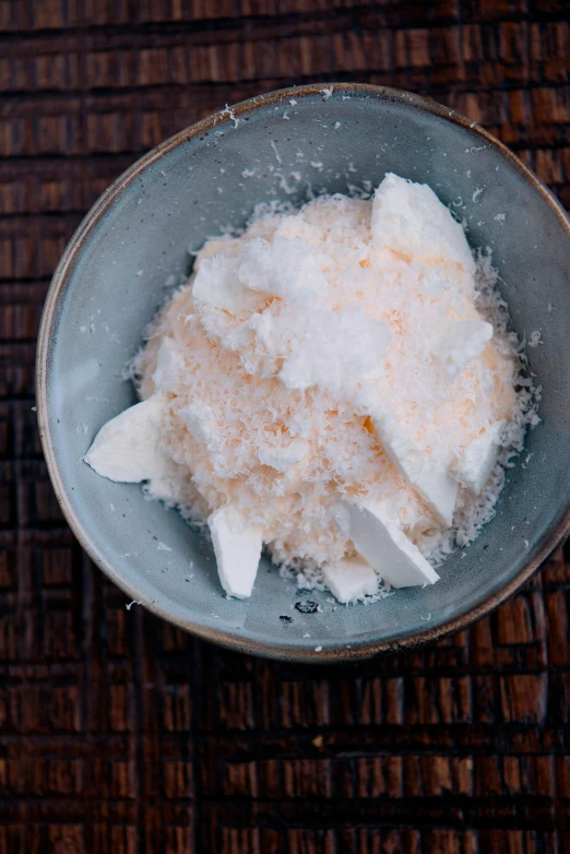 a bowl of sugar sitting on top of a wooden table, inspired by Nishida Shun'ei, unsplash, process art, cheeses, gushy gills and blush, coconuts, white and orange