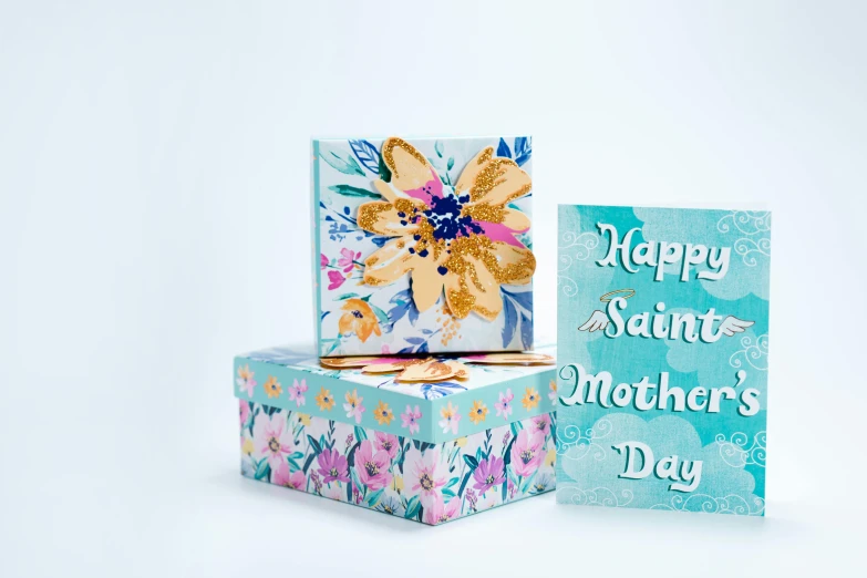 a couple of boxes sitting next to each other, by Elaine Hamilton, floral pattern, teal paper, say, mother sarah artist