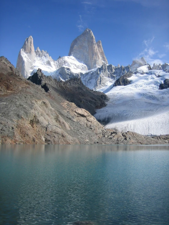 a body of water with a mountain in the background, majestic spires, cam de leon, ice blue, brancusi