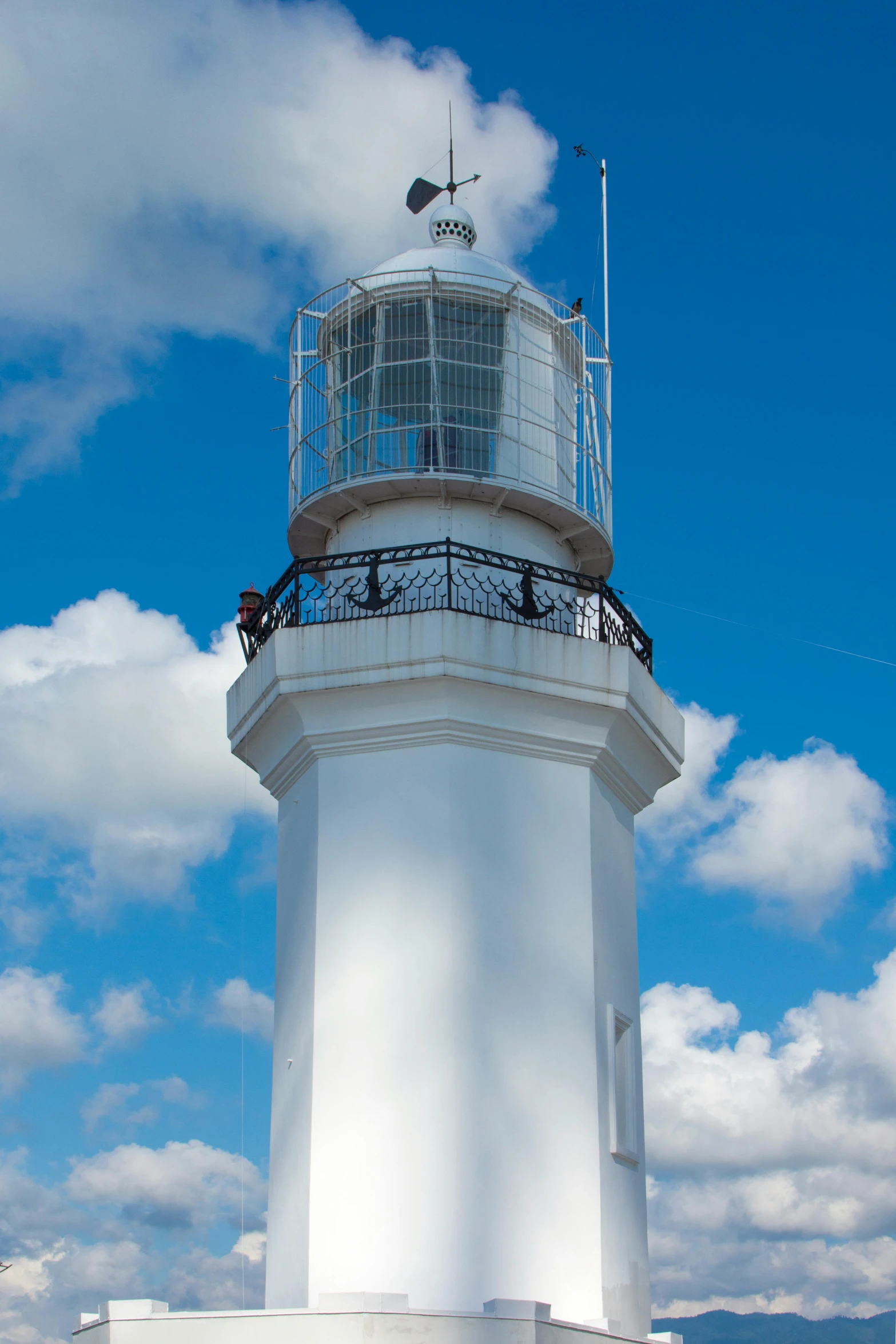 a white lighthouse with a blue sky in the background, wellington, bright internal light, square, strong rim light