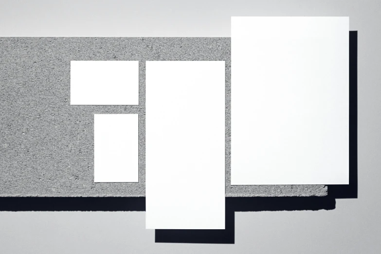 a piece of paper sitting on top of a table, inspired by Malevich, panels, visual identity, grey, various sizes