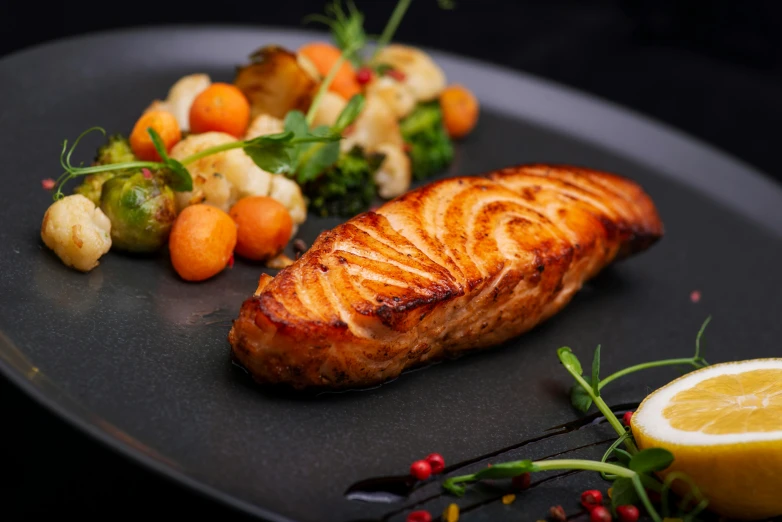 a close up of a plate of food on a table, fish tail, offering a plate of food, in front of a black background, chiseled good looks