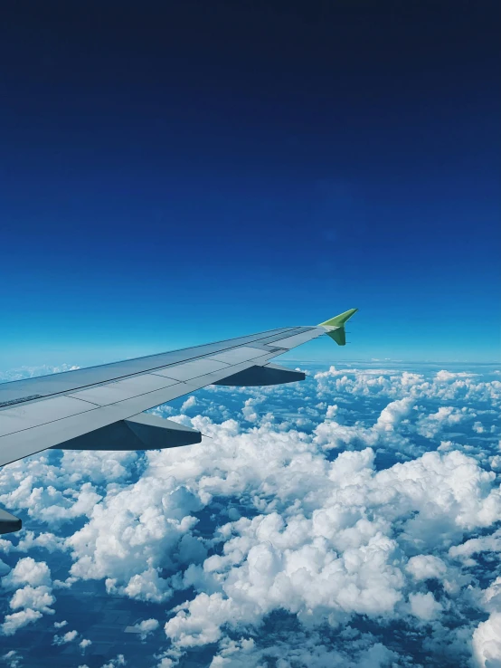 the wing of an airplane flying above the clouds, pexels contest winner, green and blue, 🚿🗝📝, profile image