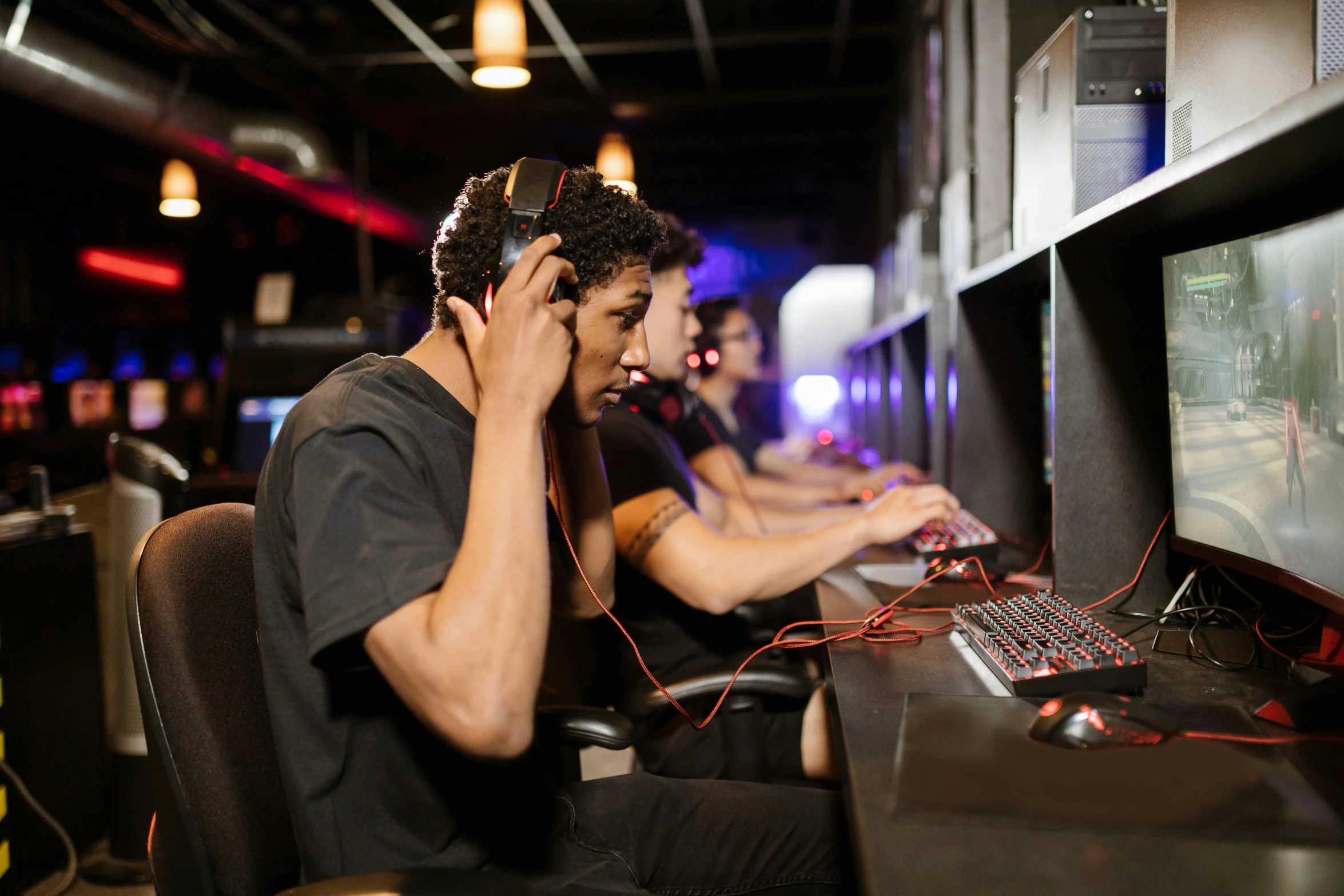 a man talking on a cell phone while sitting in front of a computer, sierra entertainment games, floating headsets, team ibuypower, a busy arcade