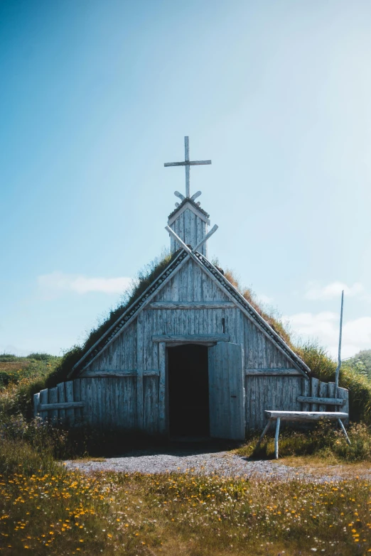 a small wooden church with a cross on top of it, by Jesper Knudsen, trending on unsplash, turf roof, built around ocean, door, teepee