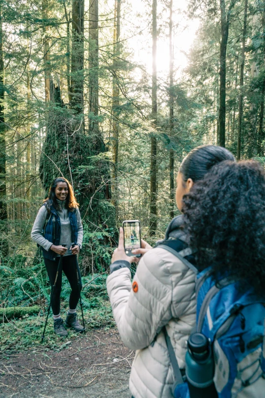 a woman taking a picture of a man in the woods, a picture, happening, cascadian, hold up smartphone, portrait of tall, cascadia