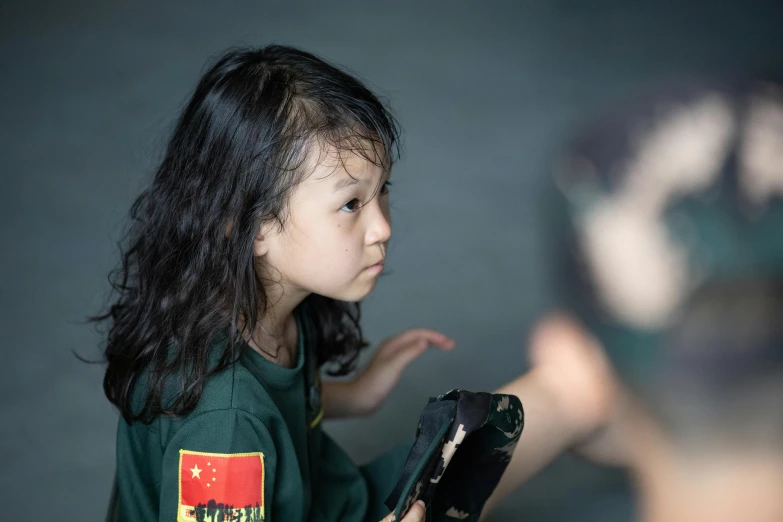 a little girl holding a remote control in her hand, a portrait, inspired by Zhang Xiaogang, pexels contest winner, portrait of combat dancer, school class, reflecting, guan yu