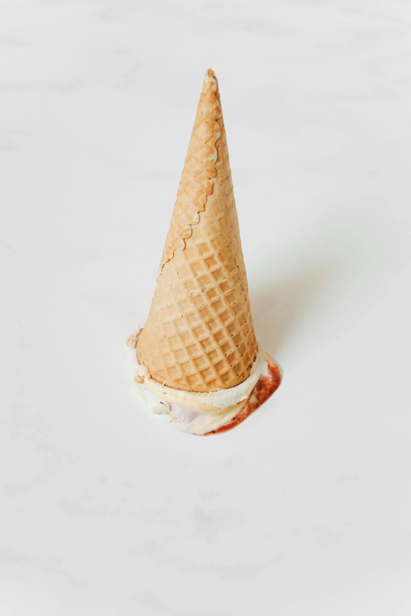 an ice cream cone sitting on top of a table, pale red, flat lay, detailed product image, beaten