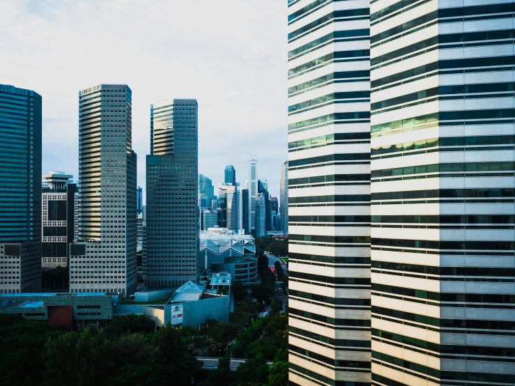 a view of a city from a high rise building, inspired by Cheng Jiasui, pexels contest winner, hyperrealism, set on singaporean aesthetic, three towers, brutalist office buildings, view from the side