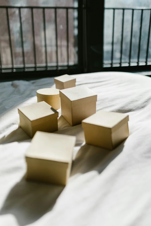 a bunch of boxes sitting on top of a bed, an abstract sculpture, trending on unsplash, soft golden light, tabletop model buildings, vanilla, poop