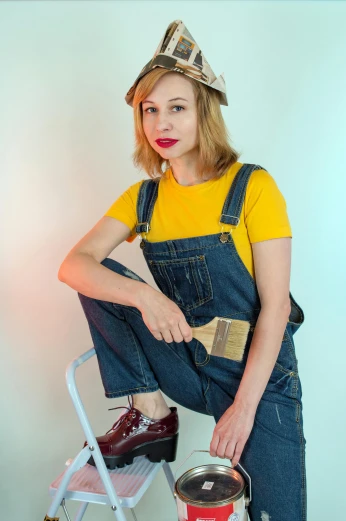 a woman in overalls is painting a wall, an album cover, inspired by Sarah Lucas, featured on reddit, wearing a modern yellow tshirt, cosplay photo, side portrait of imogen poots, 1990's photo