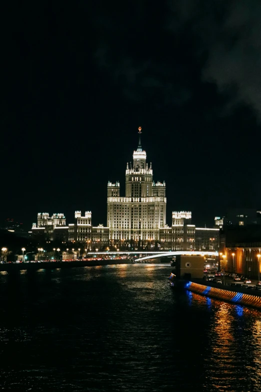 a large body of water near a city at night, an album cover, inspired by Vasily Surikov, pexels contest winner, multistory building, stalin, outside view, hotel room