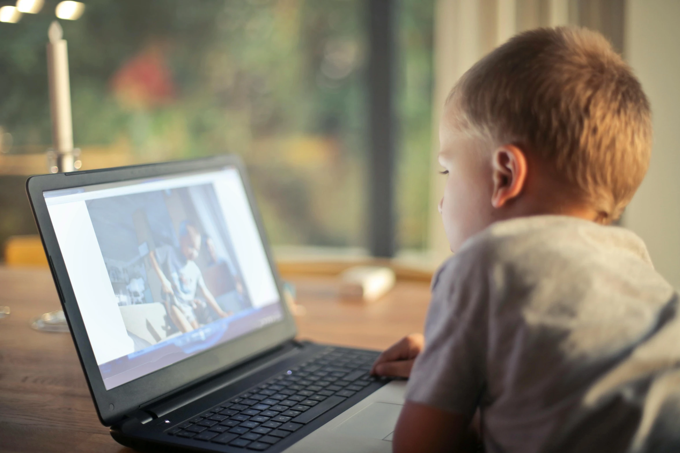 a young boy sitting in front of a laptop computer, pexels, tiny person watching, wide-screen, ignant, grown up