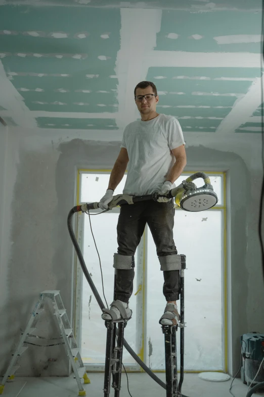 a man standing on top of a machine in a room, pexels contest winner, arbeitsrat für kunst, professional paint job, worksafe. cinematic, plaster, full body hero