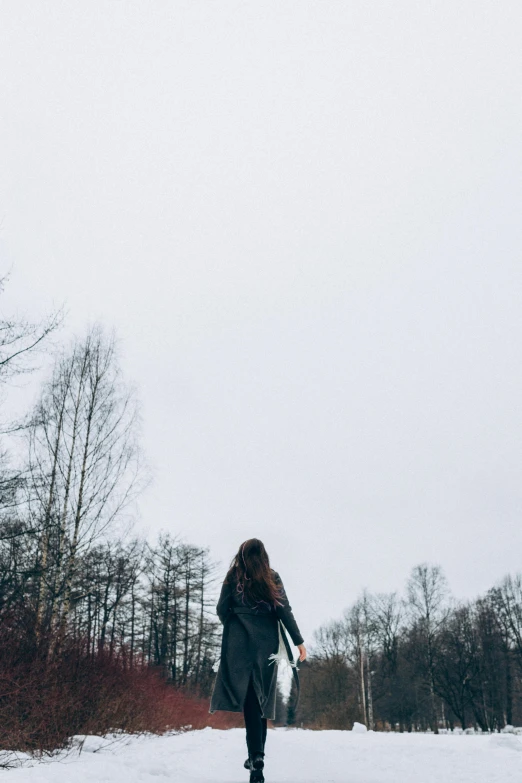 a woman walking down a snow covered road, by Anna Boch, pexels contest winner, happening, overcast gray skies, ((forest)), panoramic view of girl, looking up to the sky