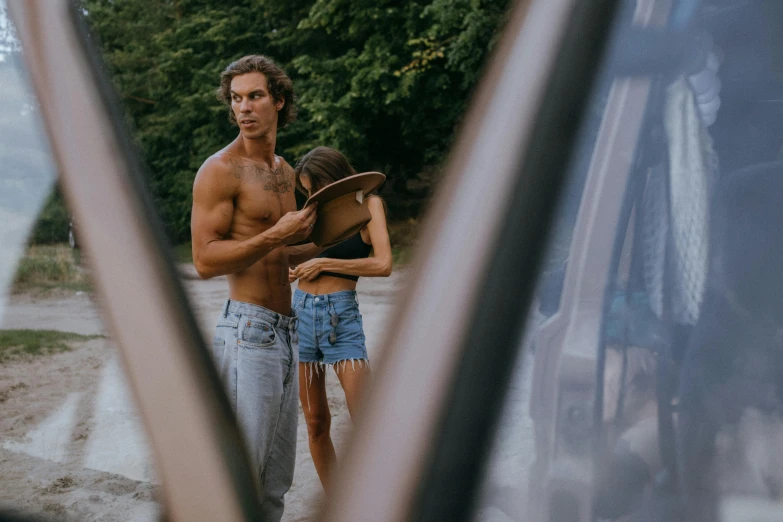 a man and a woman standing next to each other, a picture, by Jan Tengnagel, pexels contest winner, shirtless, viewed through the cars window, wavy hair spread out, looking into a mirror