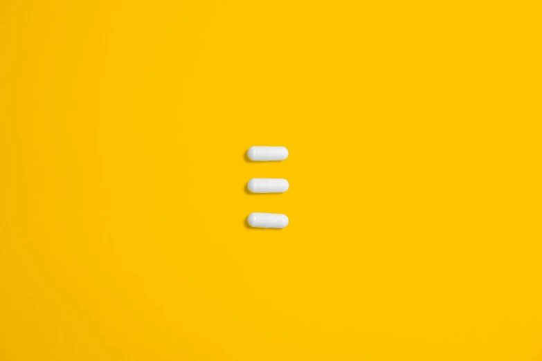 three white pills on a yellow background, by Évariste Vital Luminais, unsplash, postminimalism, shot on sony a 7 iii, ffffound, ultra minimalistic, 3 doors