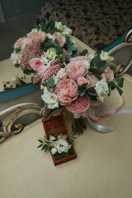 a bouquet of pink and white flowers on a chair, intricate details in the frames, on a wooden tray, with a mirror, two