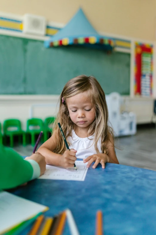 a little girl sitting at a table writing on a piece of paper, pexels contest winner, danube school, paul barson, teacher, square, toddler