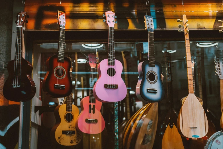 a bunch of guitars hanging on a wall, by Julia Pishtar, pexels contest winner, ukulele, colored market stand, hazy, sydney hanson