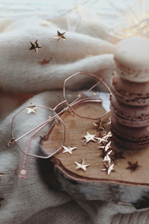 a stack of cookies sitting on top of a wooden plate, a picture, trending on pexels, magical realism, pink glasses, stars, gold, winter vibes