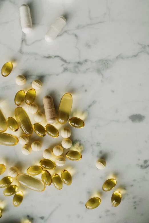 a bunch of pills sitting on top of a marble counter, by Jessie Algie, pexels, renaissance, bolts of bright yellow fish, sustainable materials, tan, medical labels