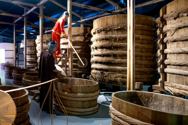 a man that is standing in front of a bunch of barrels, inspired by Li Di, incense, preserved museum piece, people at work, high-quality photo