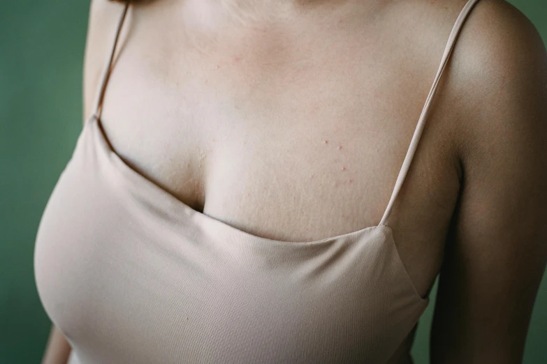 a close up of a woman wearing a tank top, by Elsa Bleda, trending on pexels, renaissance, cysts, chest coverd, wearing dress, smooth tan skin