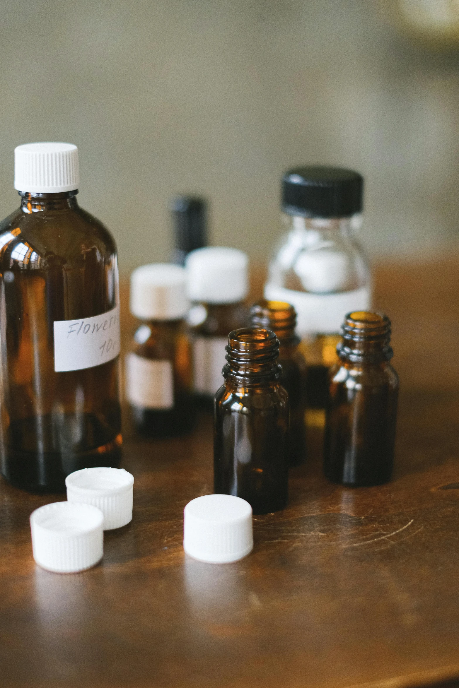 a group of bottles sitting on top of a wooden table, unsplash, medical lab, sweet almost oil, brown, profile picture