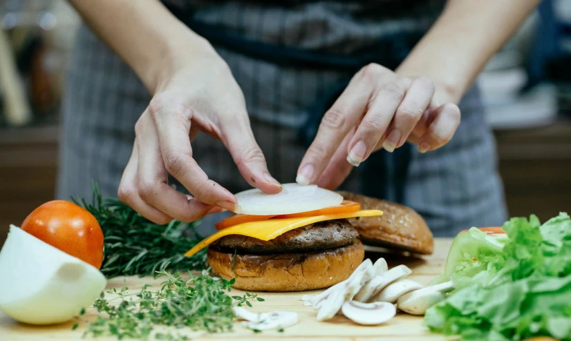 a person preparing a hamburger on a cutting board, by Julia Pishtar, profile image, fan favorite, cheeses, avatar image