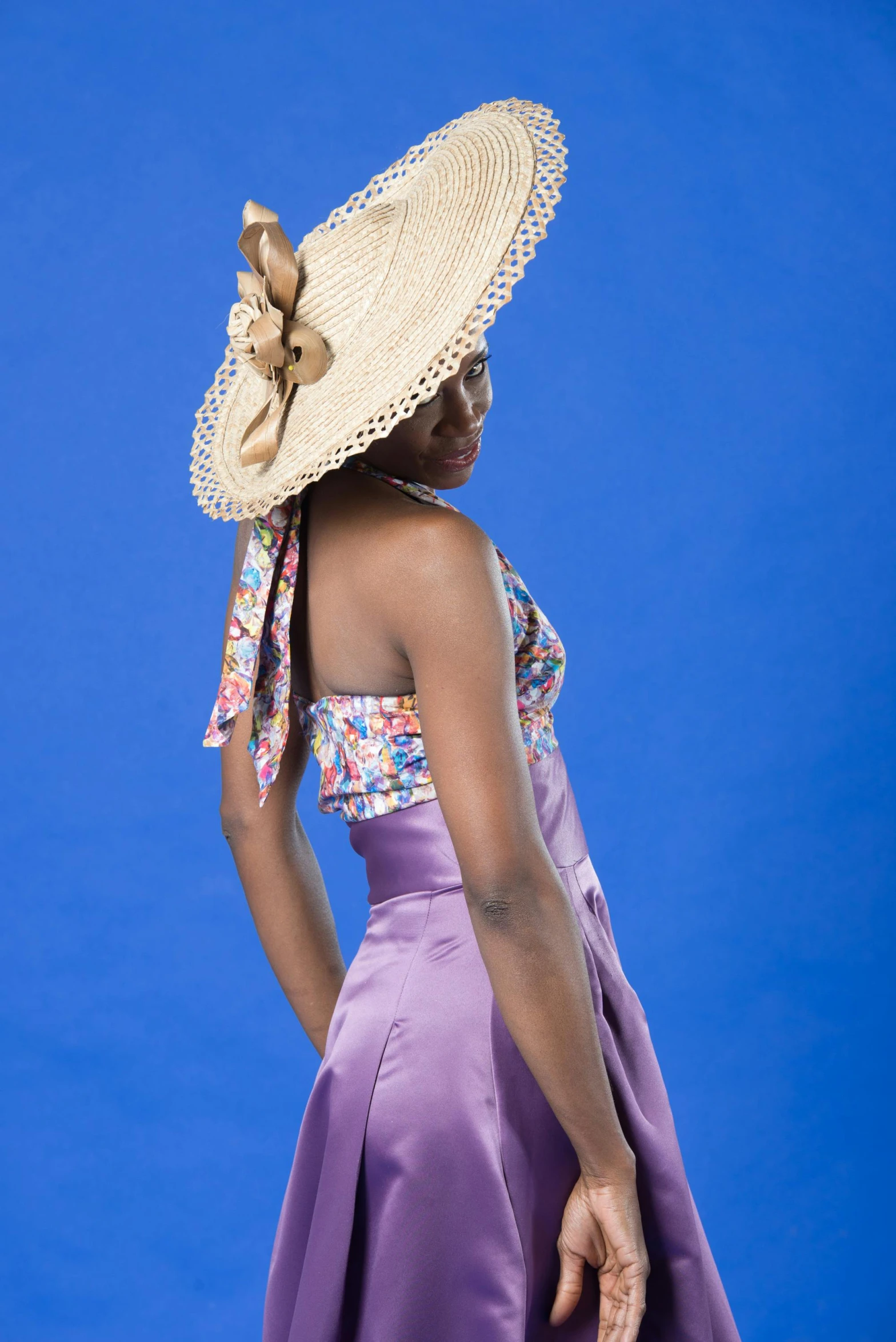 a woman in a purple dress and a straw hat, promotional photoshoot, ( ( dark skin ) ), vibrant.-h 704, promo shoot